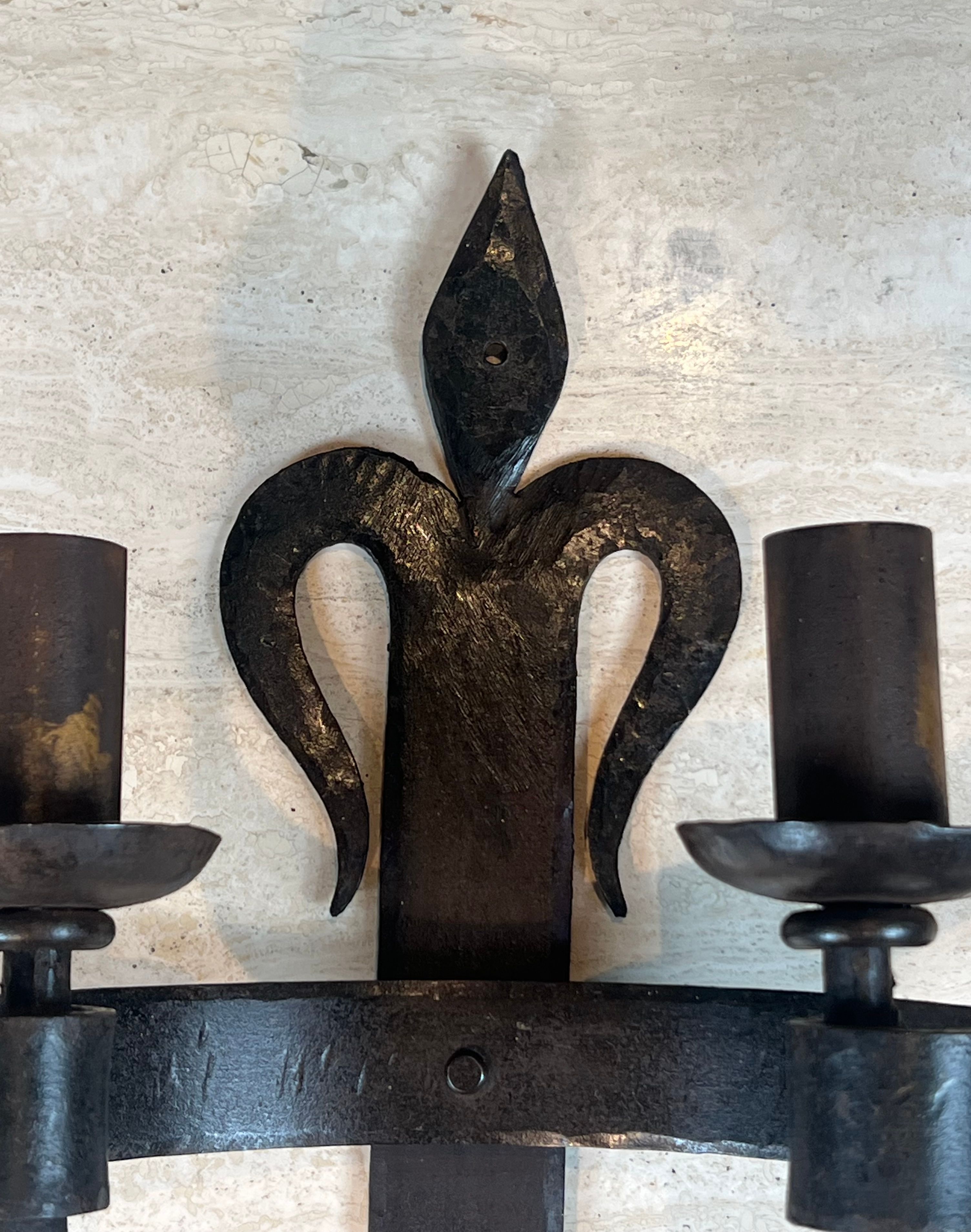 Important pair of wrought iron wall sconces "with fleur-de-lis" featuring 2 light arms in Gothic style.