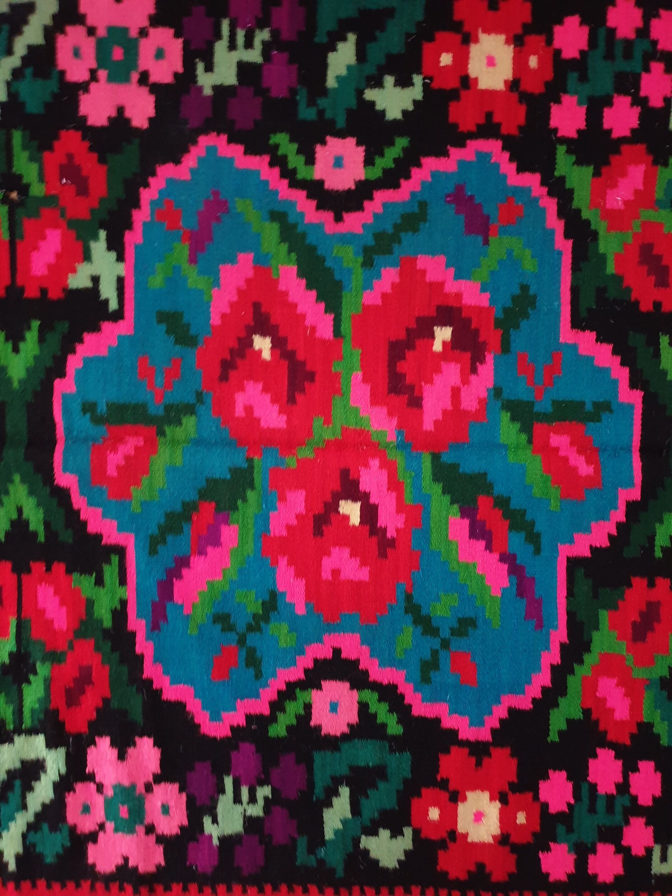 Colorful kilim on black background with floral design