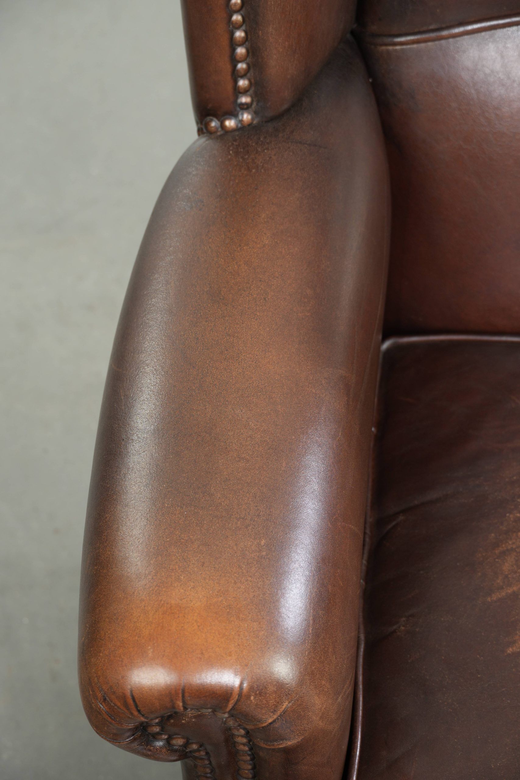 Subtle sheepskin wingback armchair with a deep cognac colour