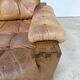 A lovely living room set comprising a pair of armchairs, a tan leather sofa and its ottoman