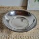 Shallow round metal plate with pearl bead decoration.