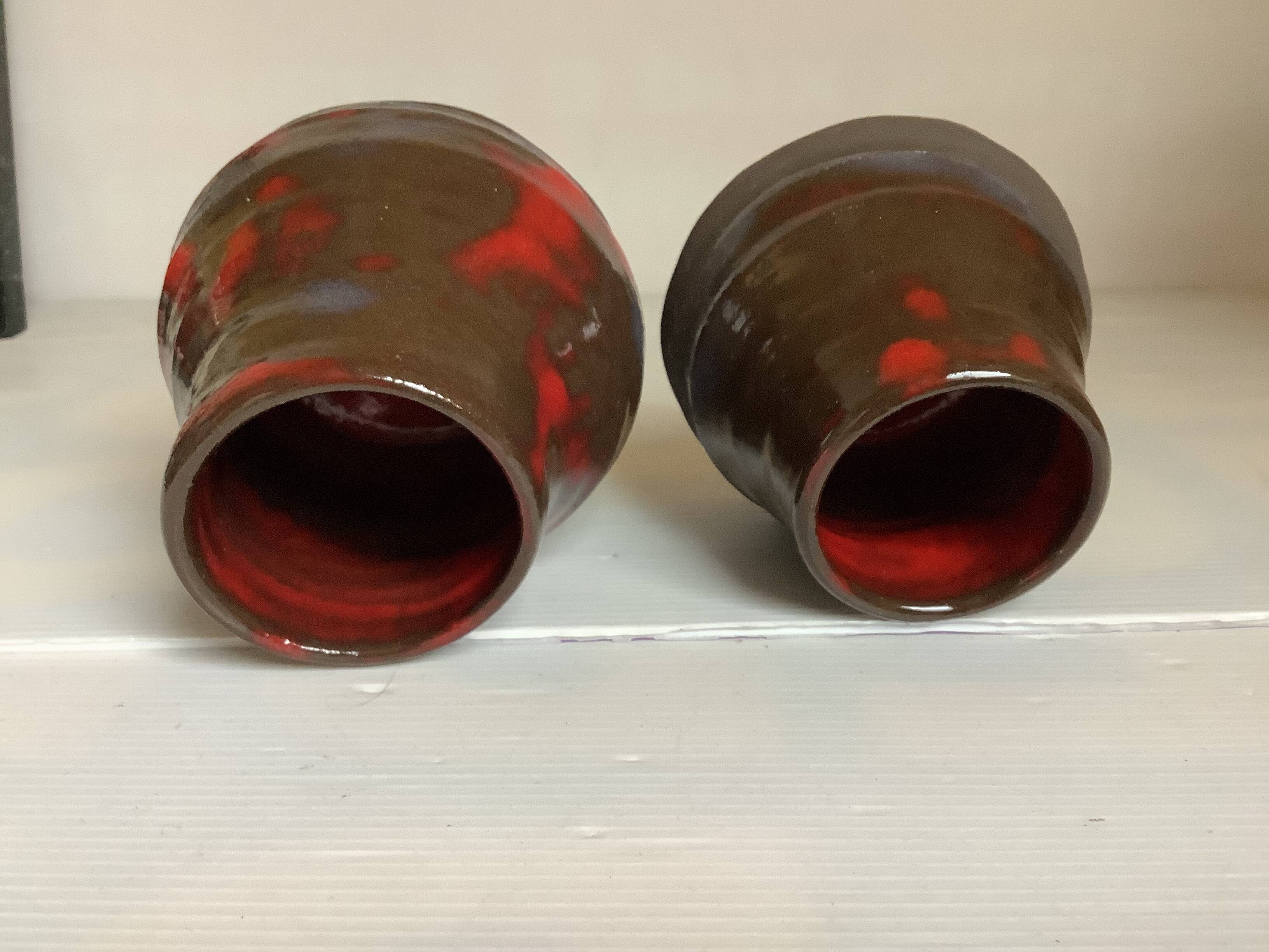 Pair of red vases in the shape of an elephant's foot