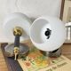Pair of wall sconces with brass torch and white glass globe.