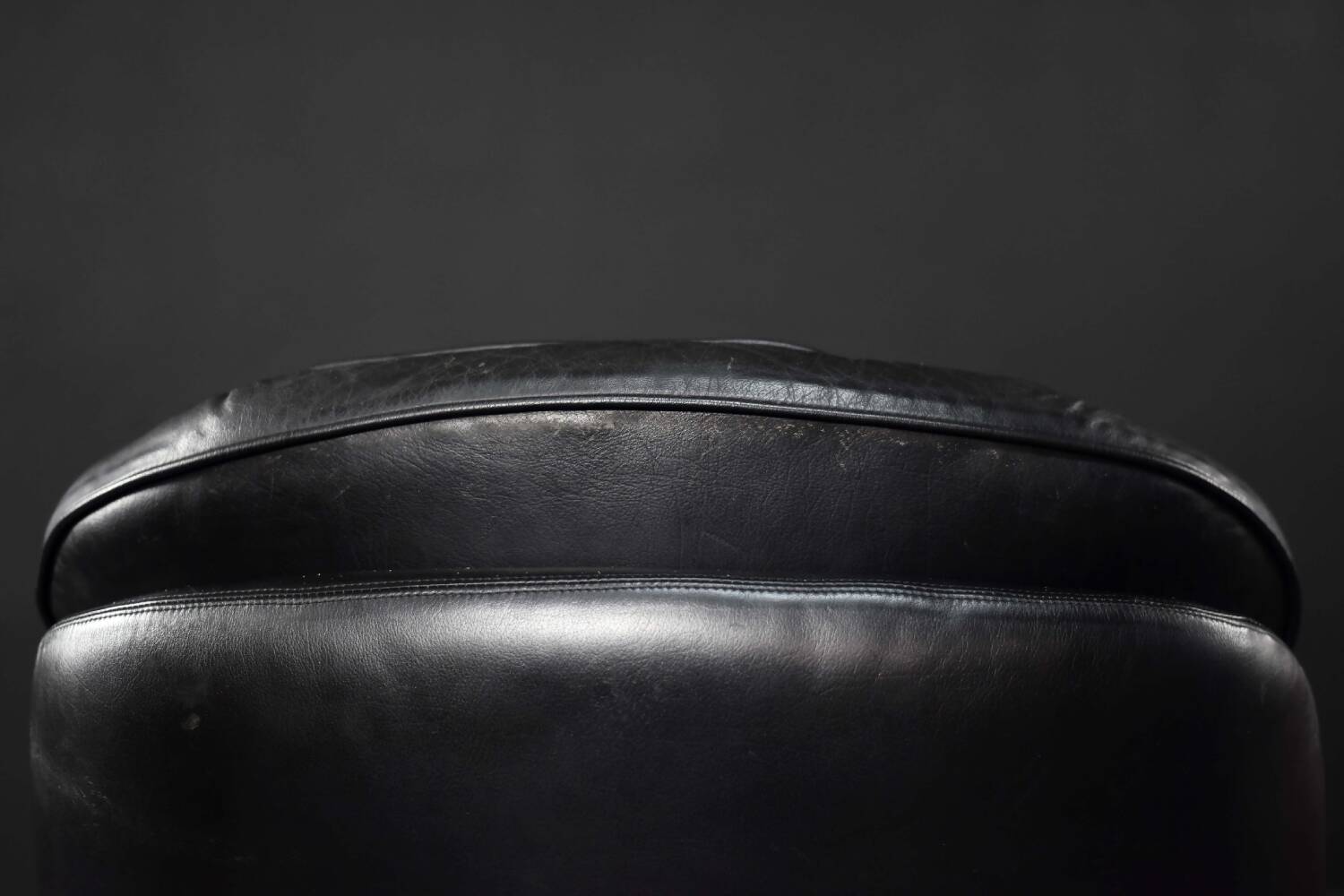Vintage black leather swivel chair in mid-century modern Scandinavian style.