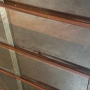 Vintage 1960s wooden library with sliding doors.