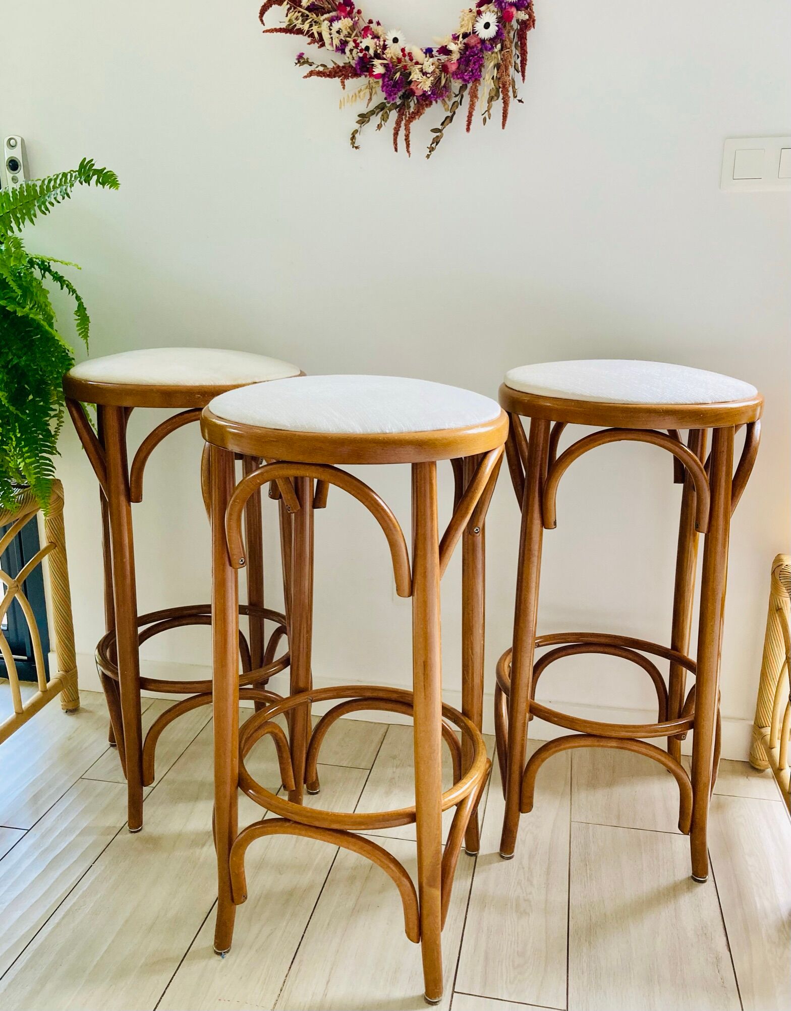 3 bar stools made of curved wood and fabric seat