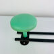Wall-mounted coat rack with 2 green hooks from the 1950s.