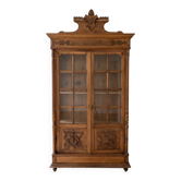 Antique wooden library with a carved pediment.