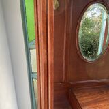 Antique wooden coat rack with mirror and shelf.