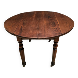 Old round table with folding shutters on casters in solid wood in very good condition