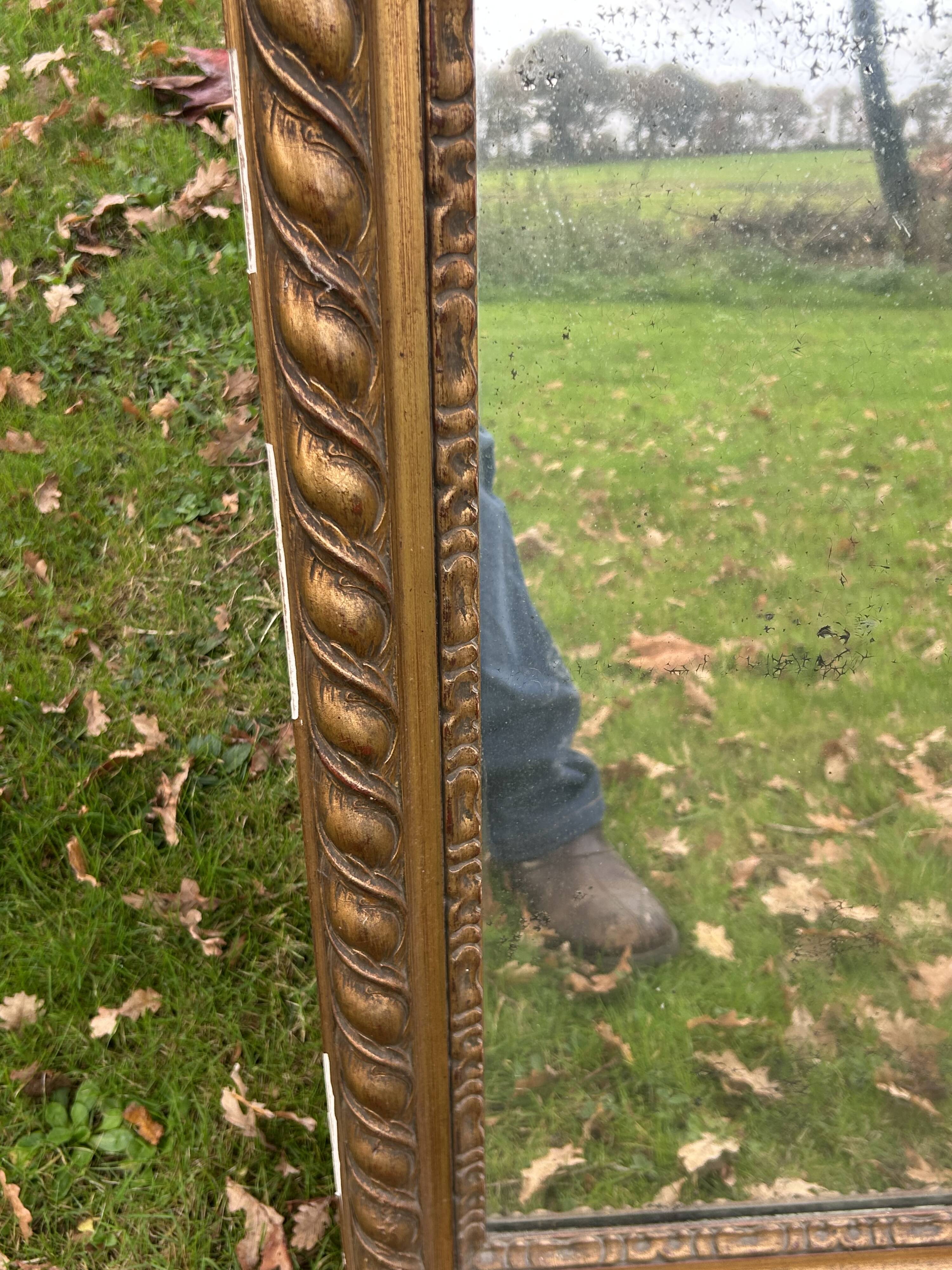 Large antique gilded mirror, wood and stucco gadroons, partially de-mercury