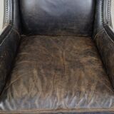 Black cow leather armchair in industrial style finished with decorative nails