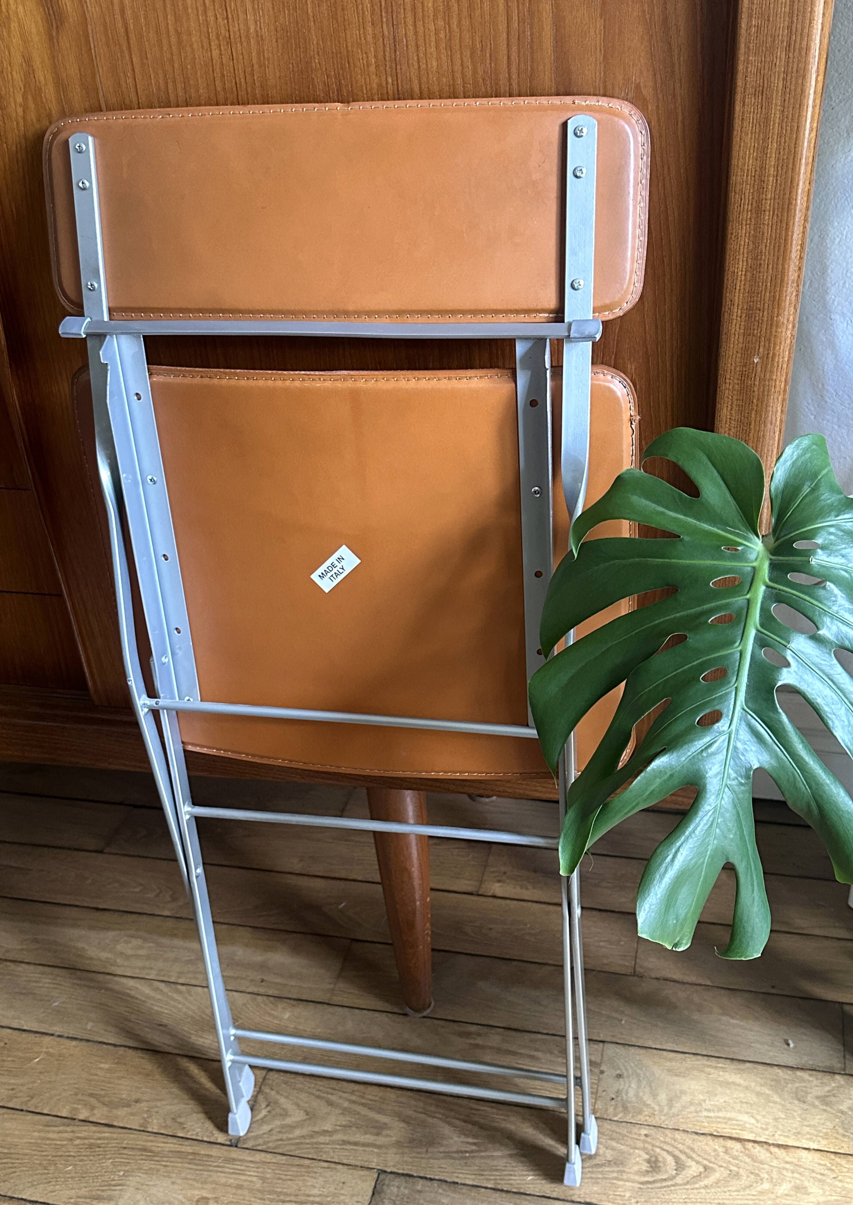 4 folding Sintesi chairs for DWR Lina in metal and vintage camel leather.