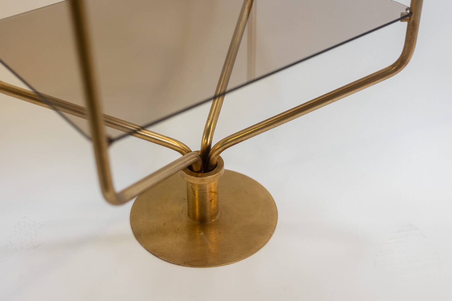 Free-standing shelf in gilded brass with smoked glass shelves. 1970s.