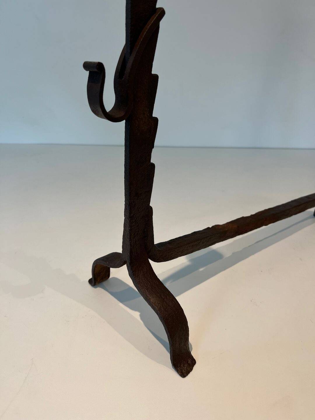 Pair of wrought iron andirons with adjustable supports and tripod feet.
