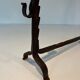 Pair of wrought iron andirons with adjustable supports and tripod feet.