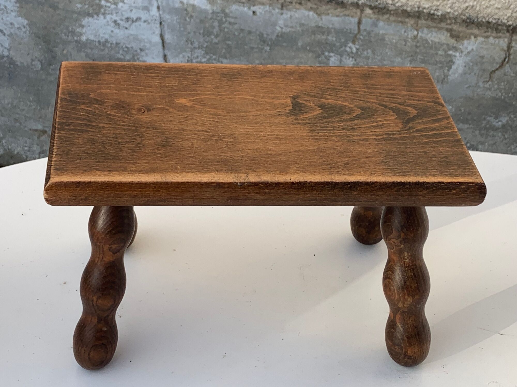 Footstool in varnished wood turns old