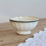 Old ivory ceramic bowl with double green trim.