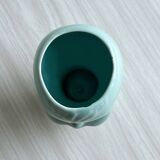 Turquoise plant pot in the shape of a vintage doll's head.