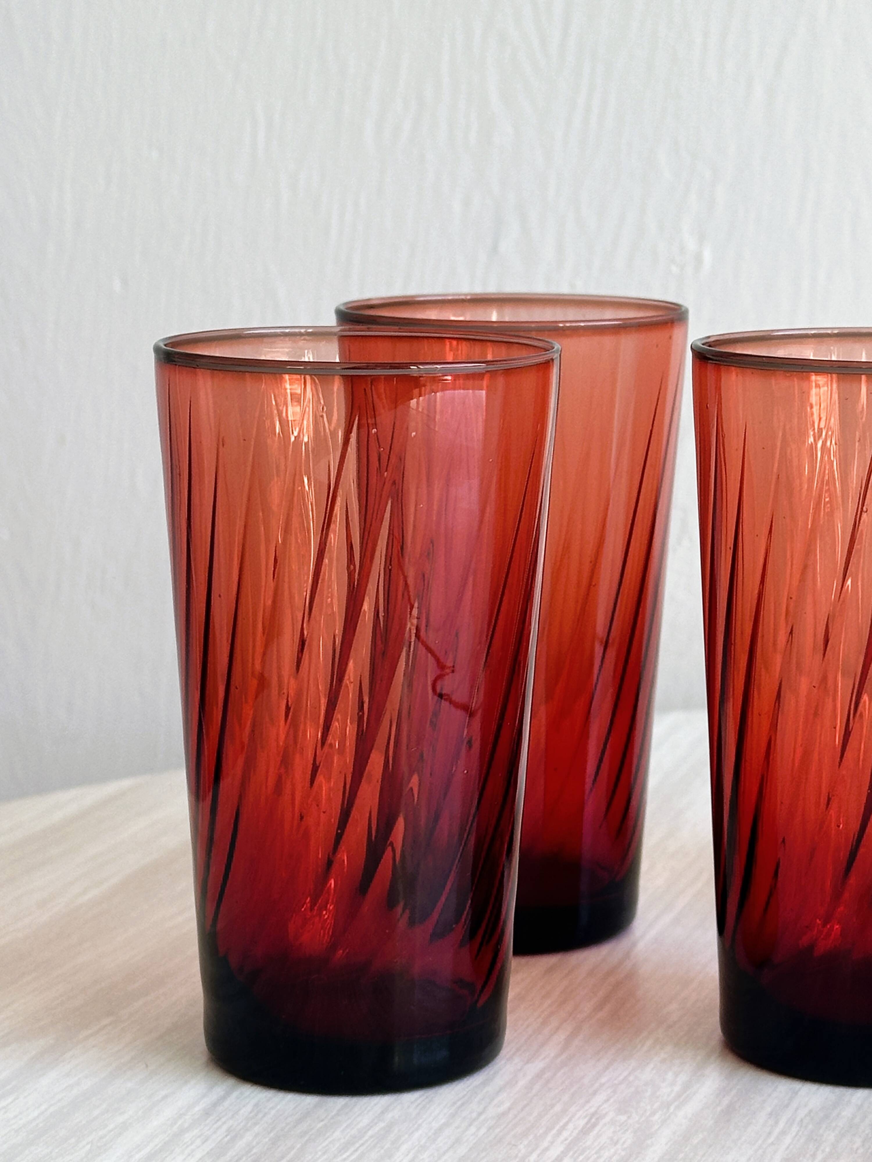 4 verres à eau rouges translucides.