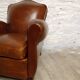 Antique club chair with gendarme hat back