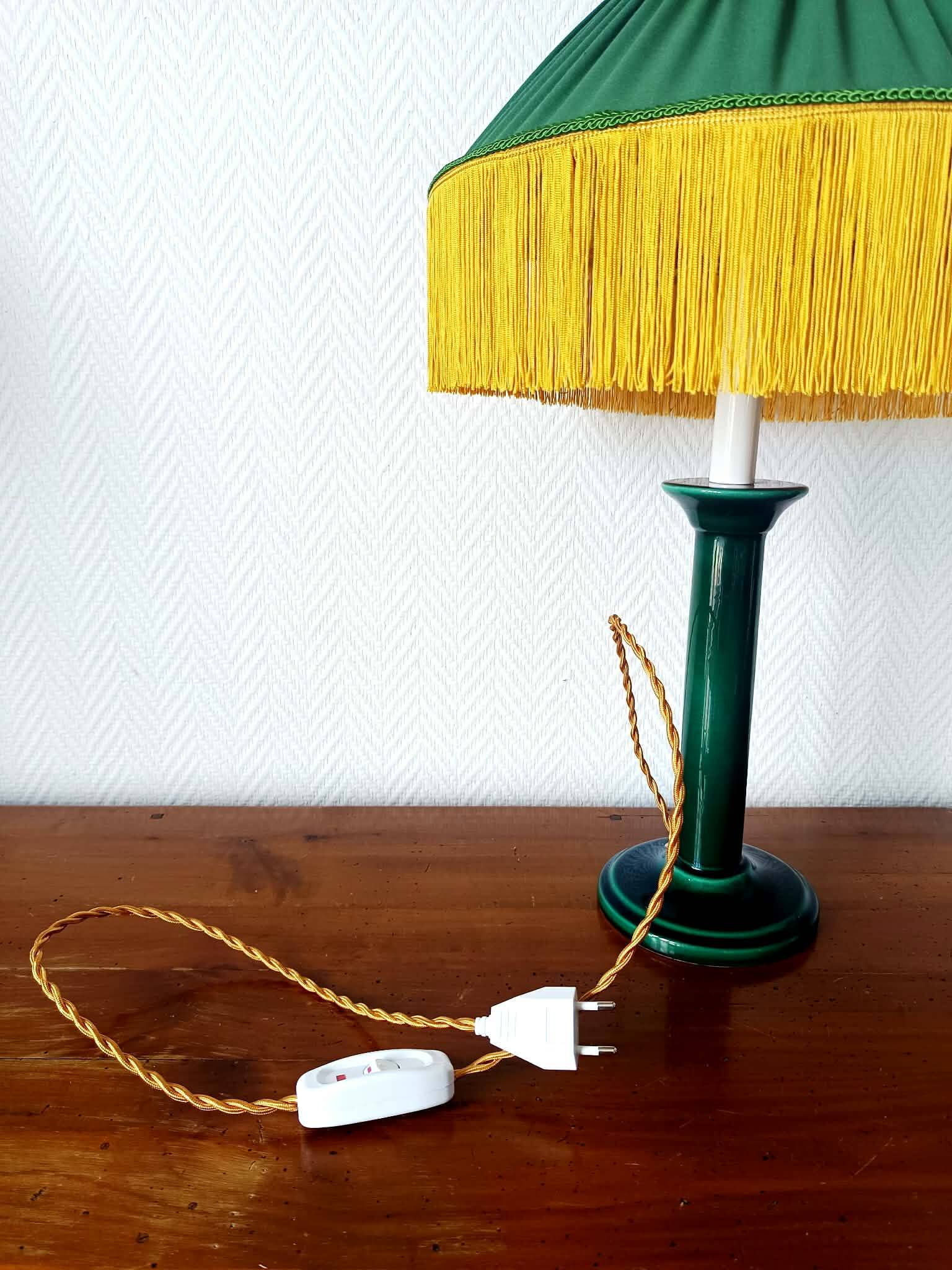 Green ceramic lamp with a vintage pleated fringe shade.