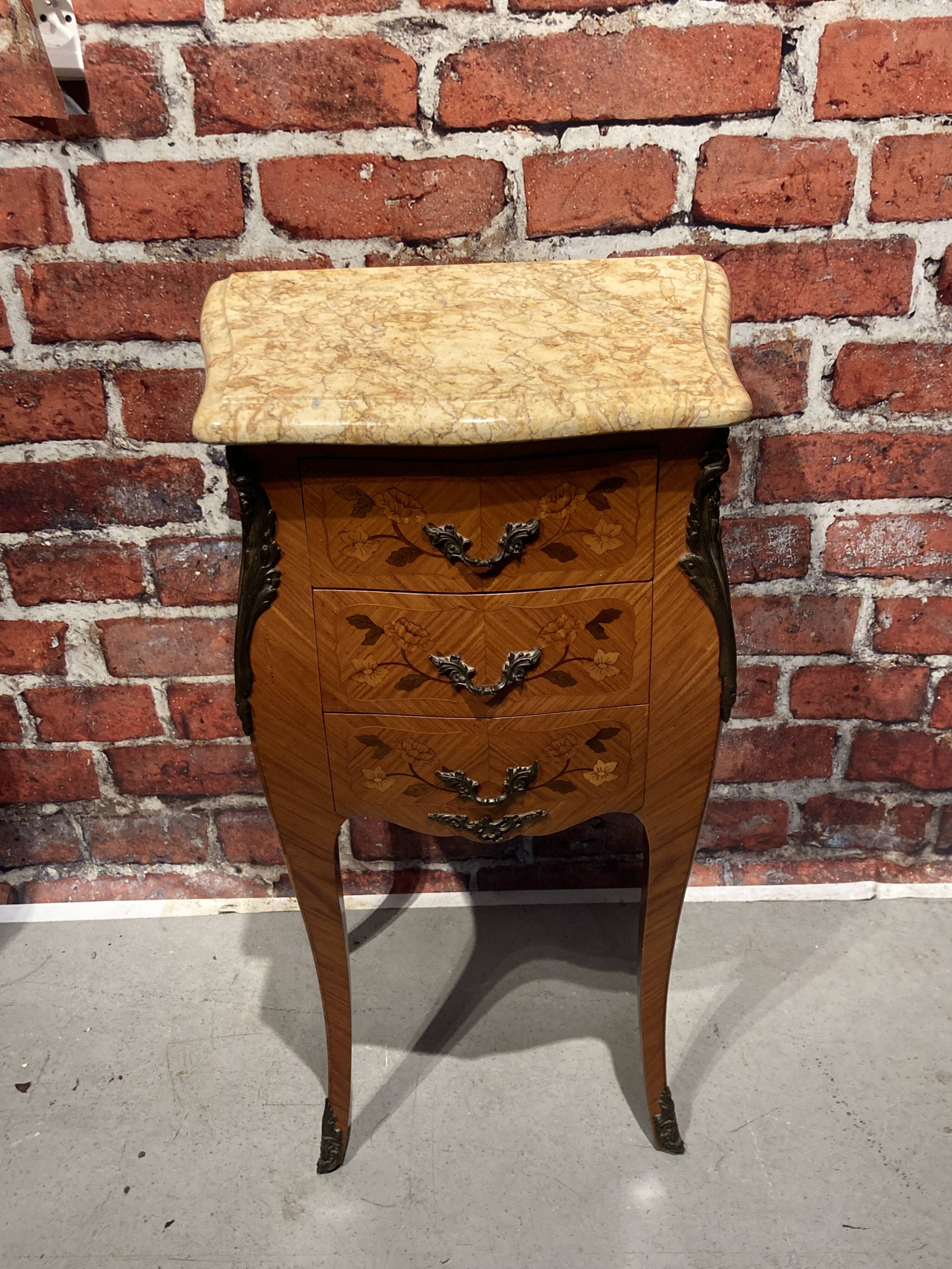 Wooden bedside table topped with a pink marble top