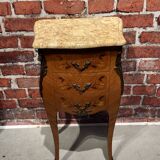 Wooden bedside table topped with a pink marble top