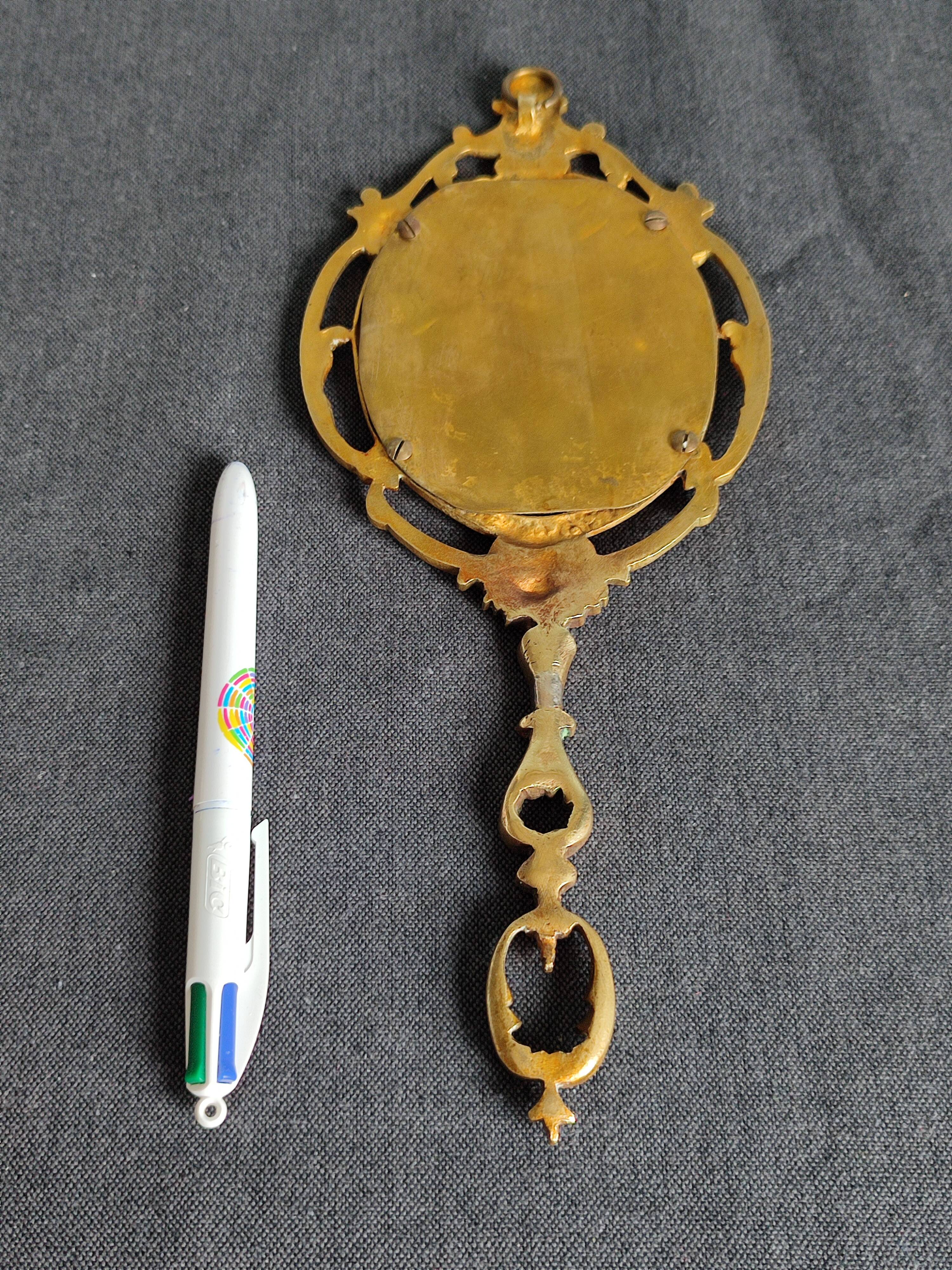 Antique hand-facing mirror in bronze and beveled glass