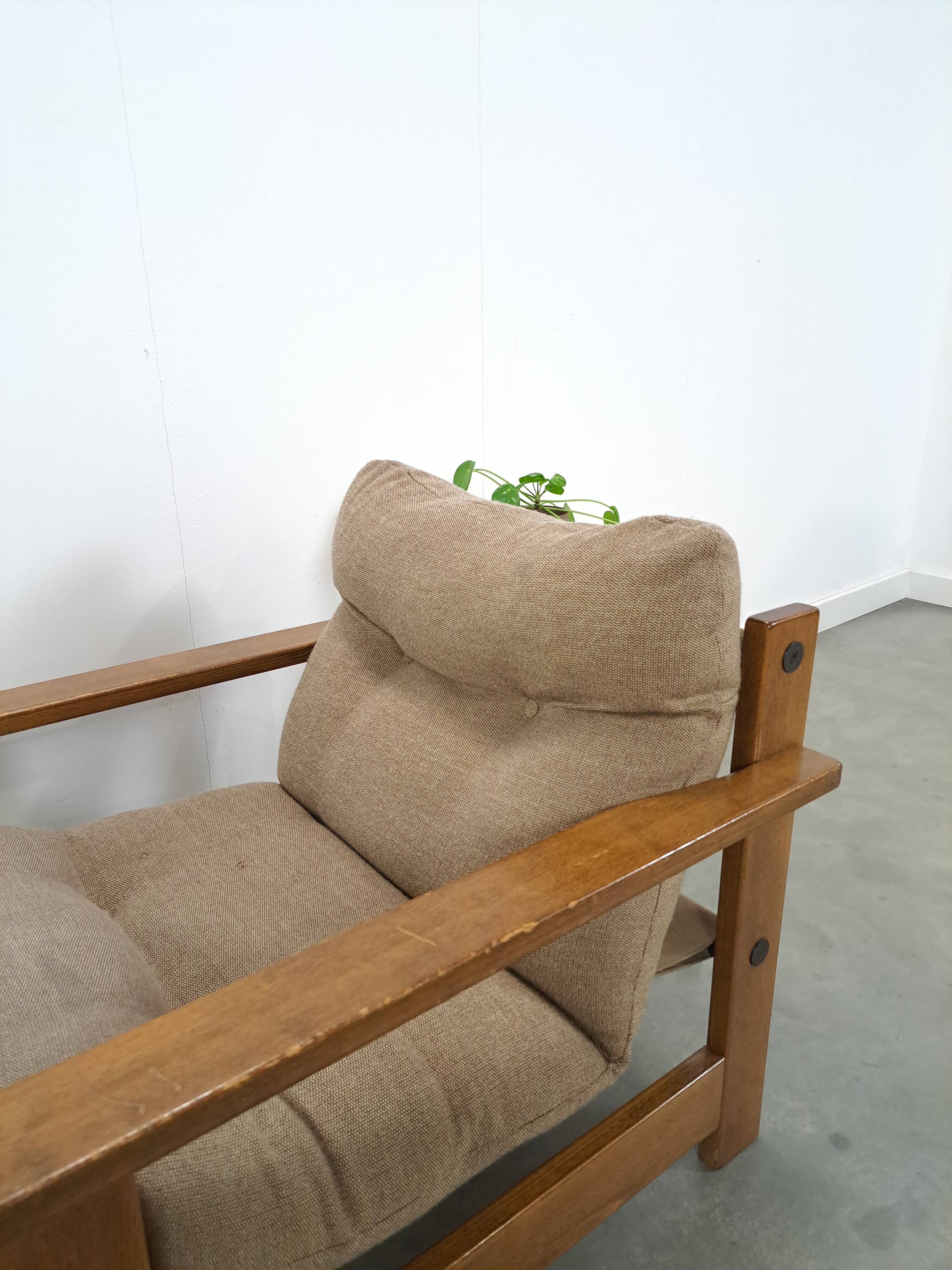 Brown-grey armchair with an oak frame.