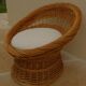 Wicker armchair with a high back and its boucle fabric cushion.