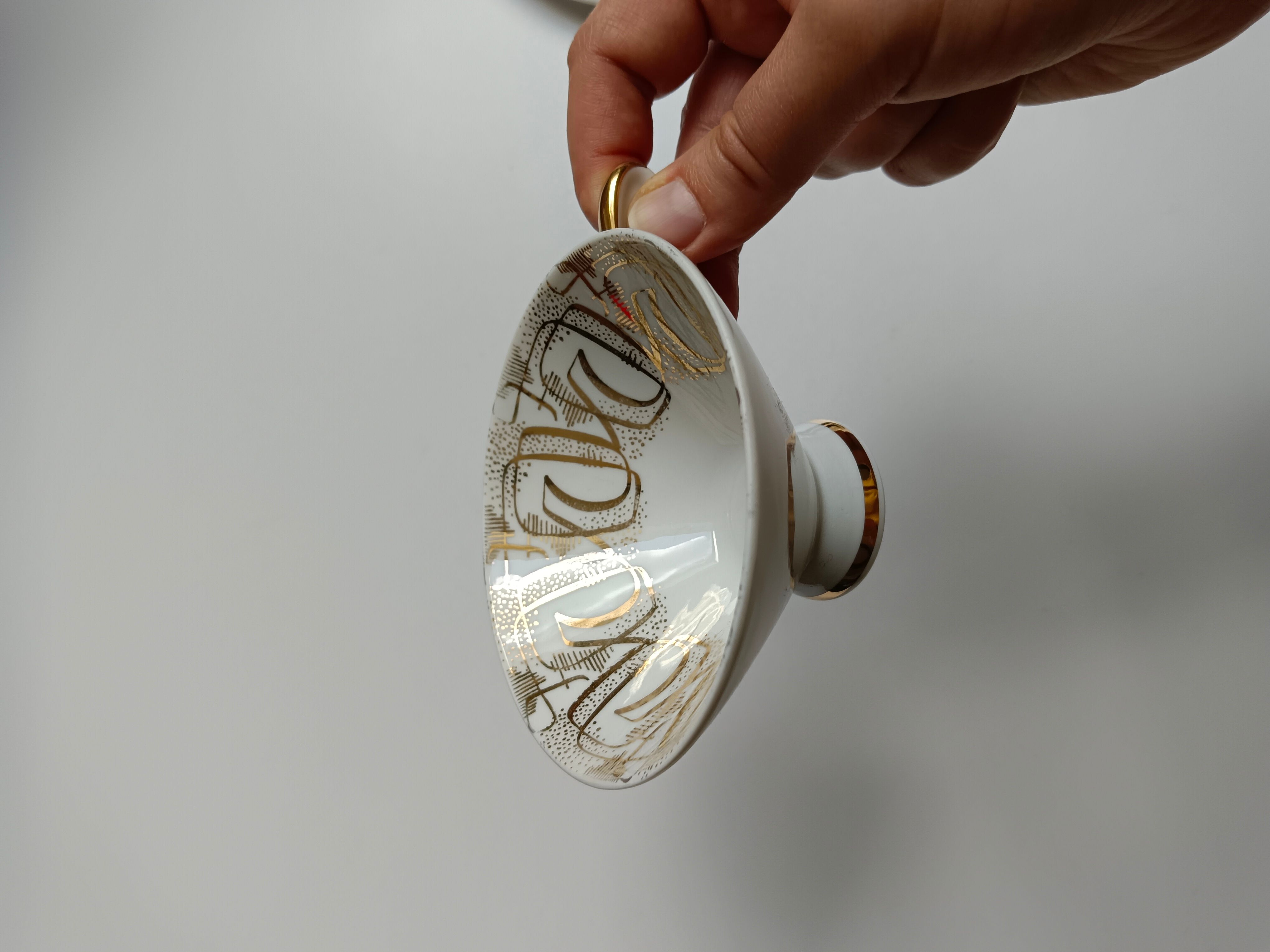 Solitaire tea cup, saucer, and dessert plate in white and gold.