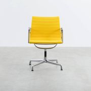 Fauteuil Aluminum Group EA107 de Charles et Ray Eames en tissu jaune.