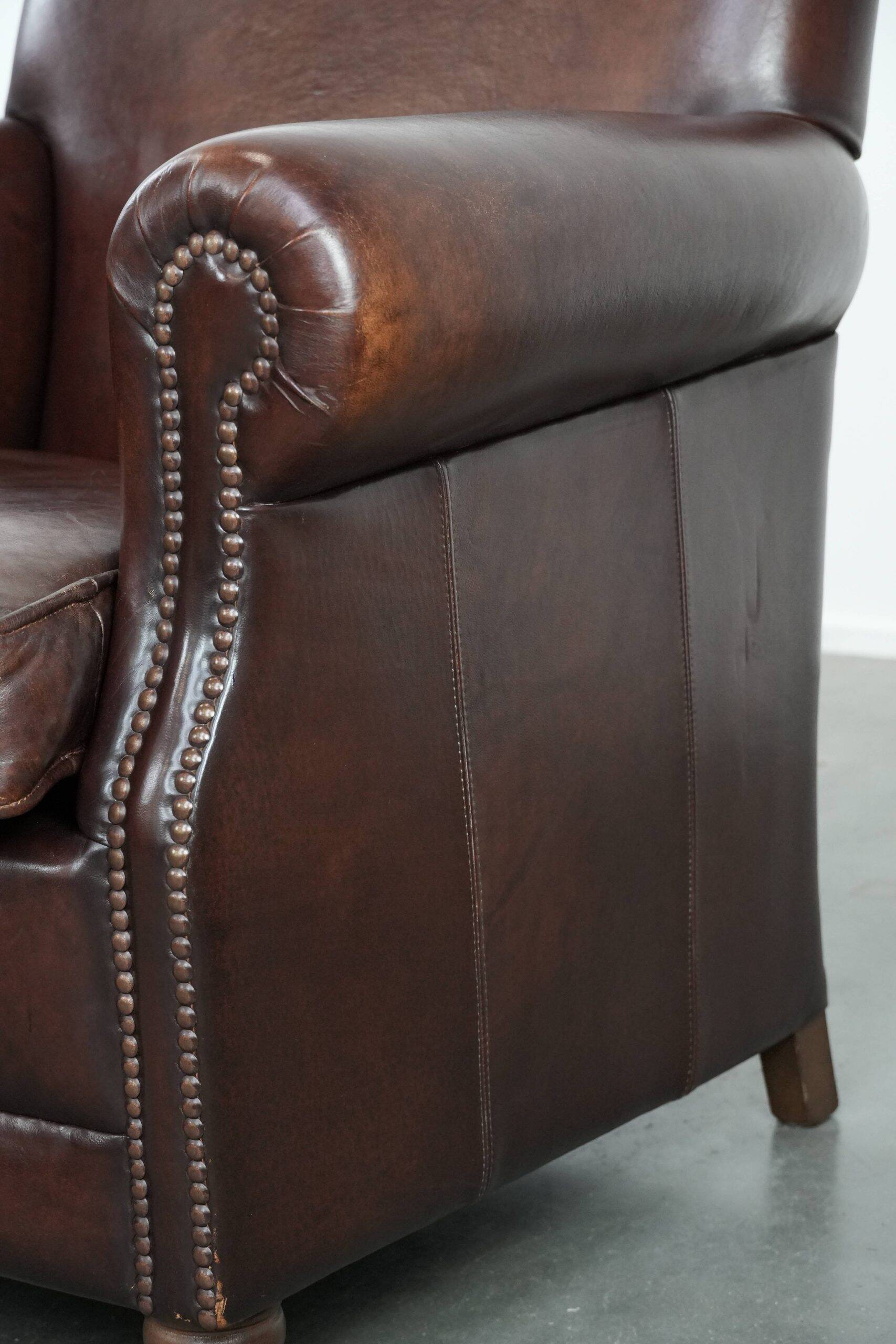 Sheepskin armchair with a classic finish and decorative studs.