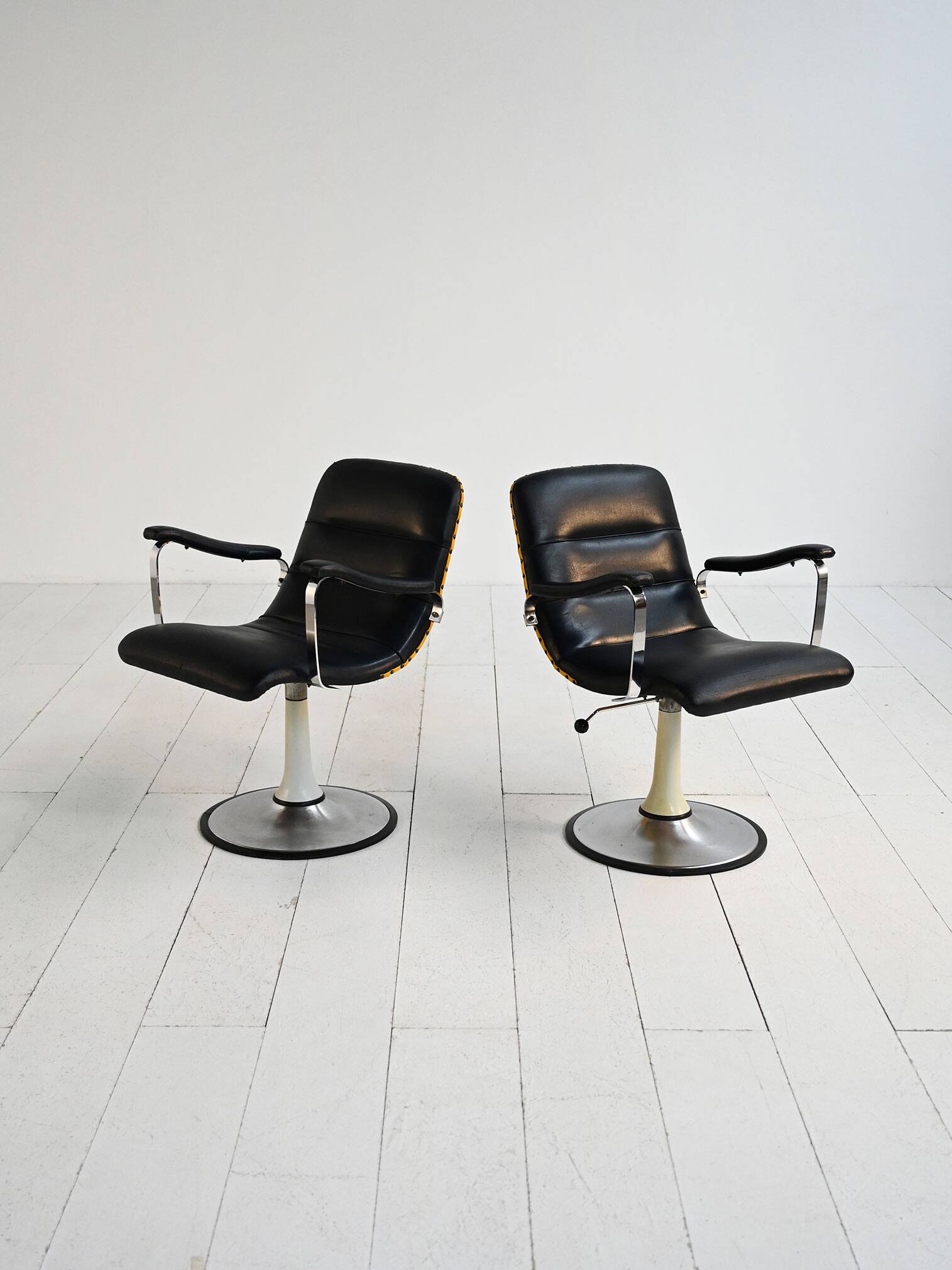 Pair of European 1970s swivel armchairs in faux leather and steel