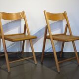 Pair of vintage wooden folding chairs with star pattern on seat