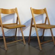 Pair of vintage wooden folding chairs with star pattern on seat