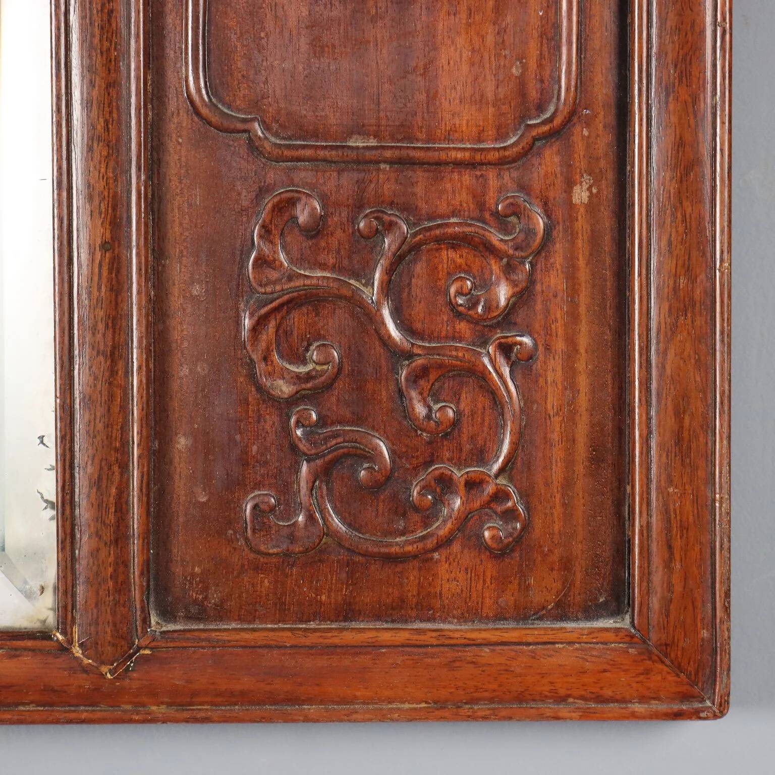 Antique mirror in exotic wood with chinoiserie carvings, 19th century.
