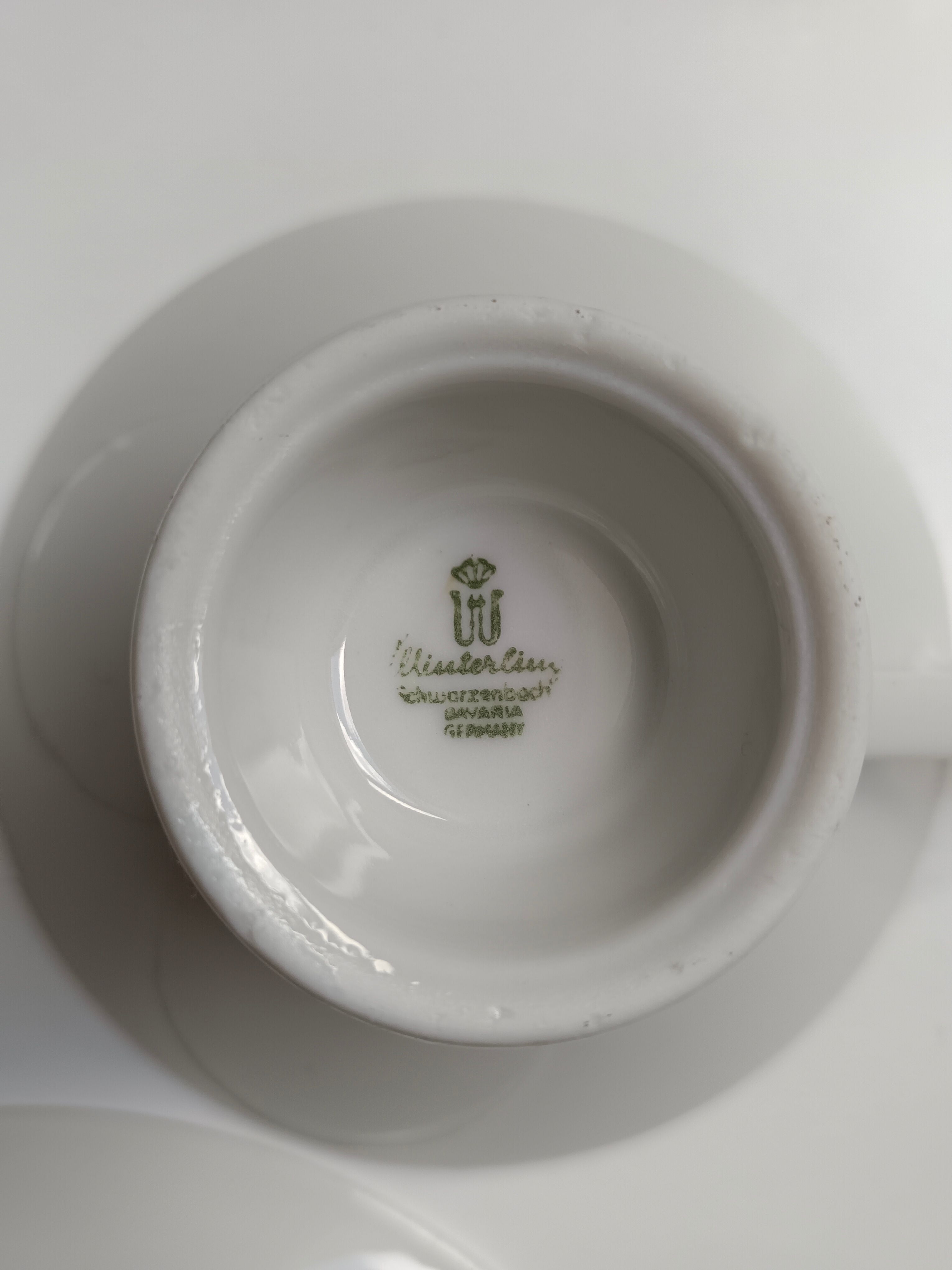 Solitaire tea cup, saucer, and dessert plate in white and gold.