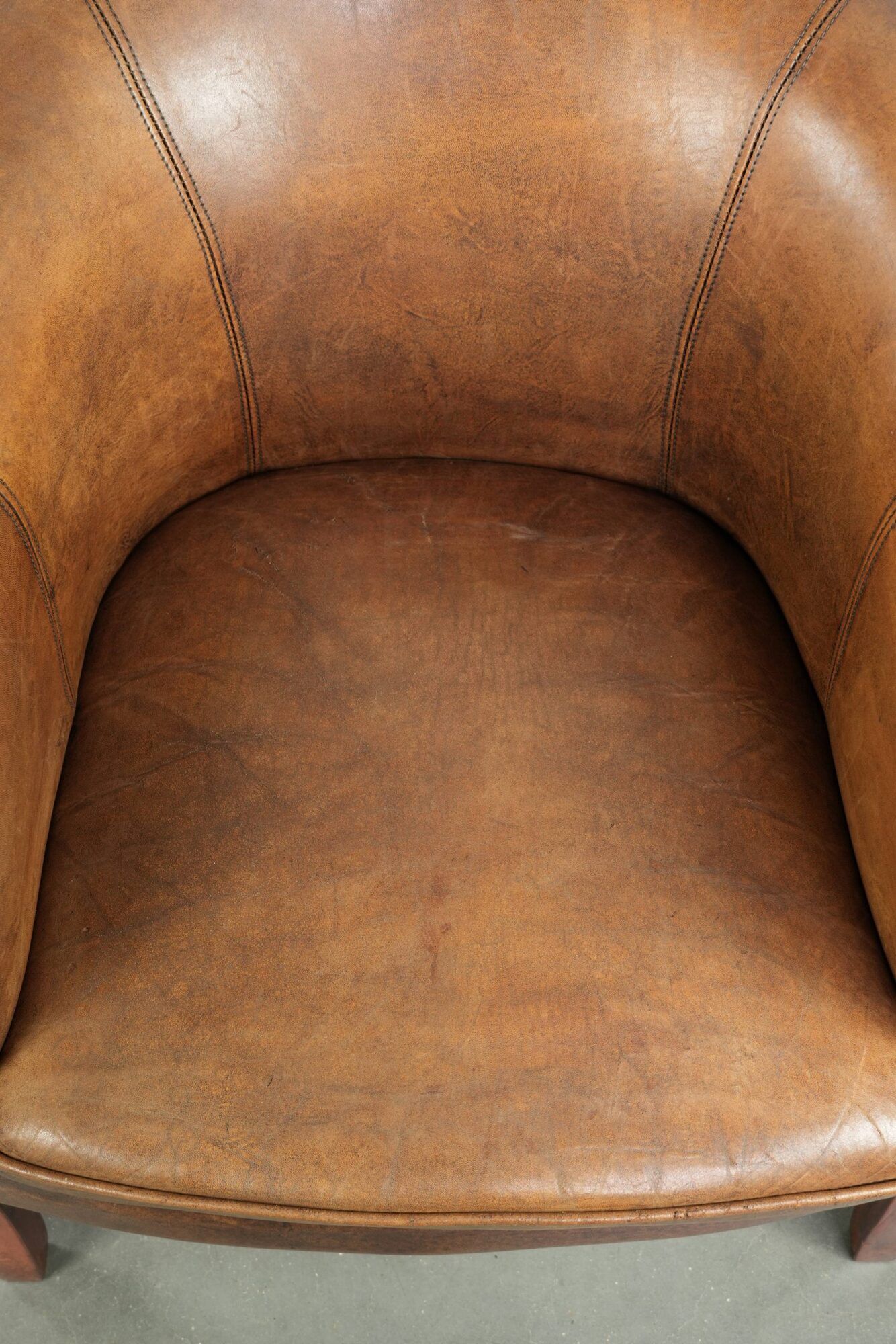 Sheepskin club armchair in a brown colour finished with decorative nails