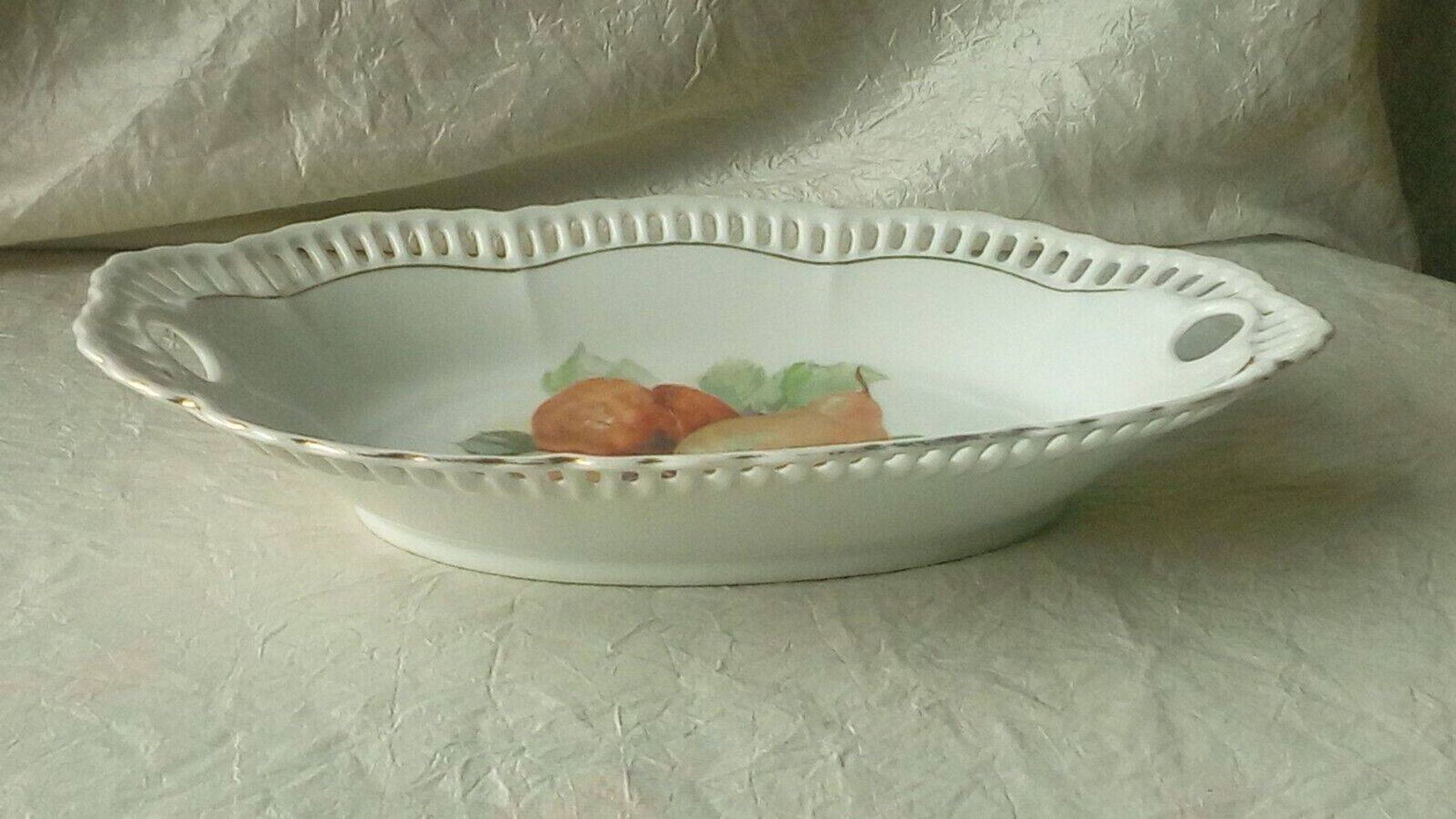 Pierced porcelain basket decorated with fruit still life.