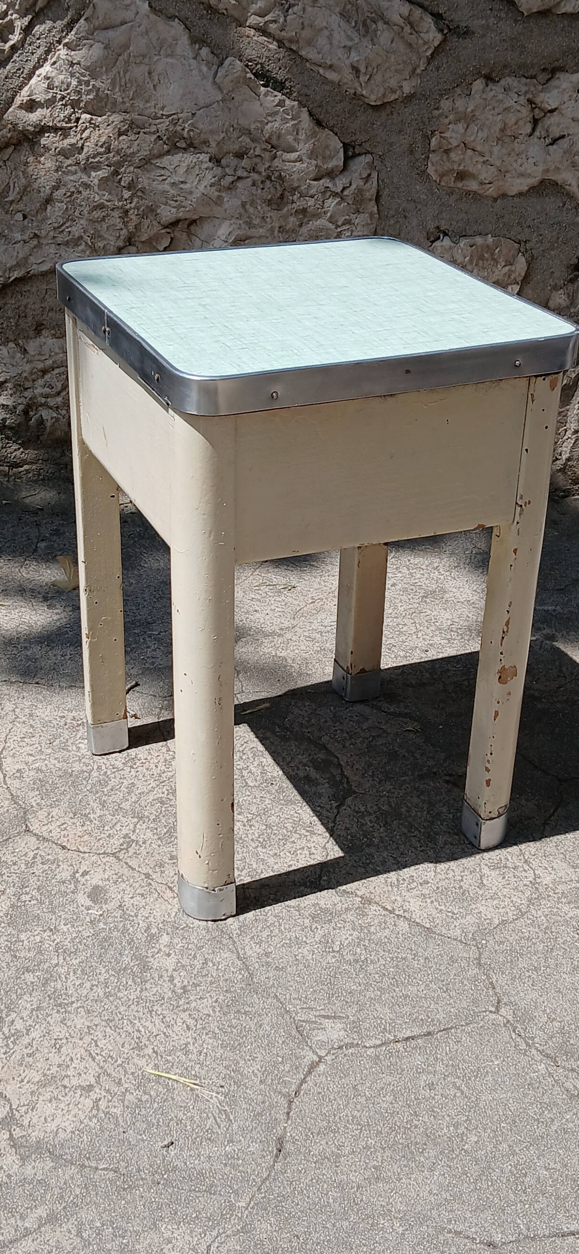 Shoe polish stool with round top and aluminum legs.