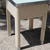 Shoe polish stool with round top and aluminum legs.