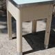 Shoe polish stool with round top and aluminum legs.