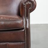 Sheepskin armchair with a classic finish and decorative studs.