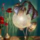 Vintage lamp with brass leaf design and transparent glass globe.