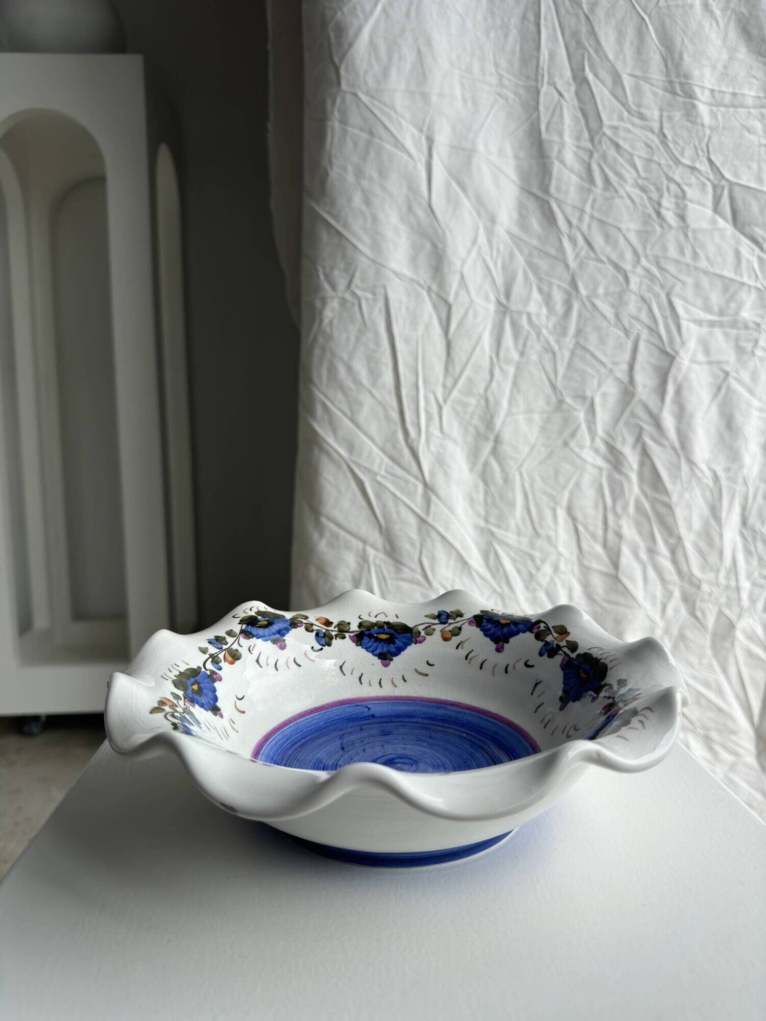 Small hand-painted earthenware salad bowl with garland of blue flowers, mark below