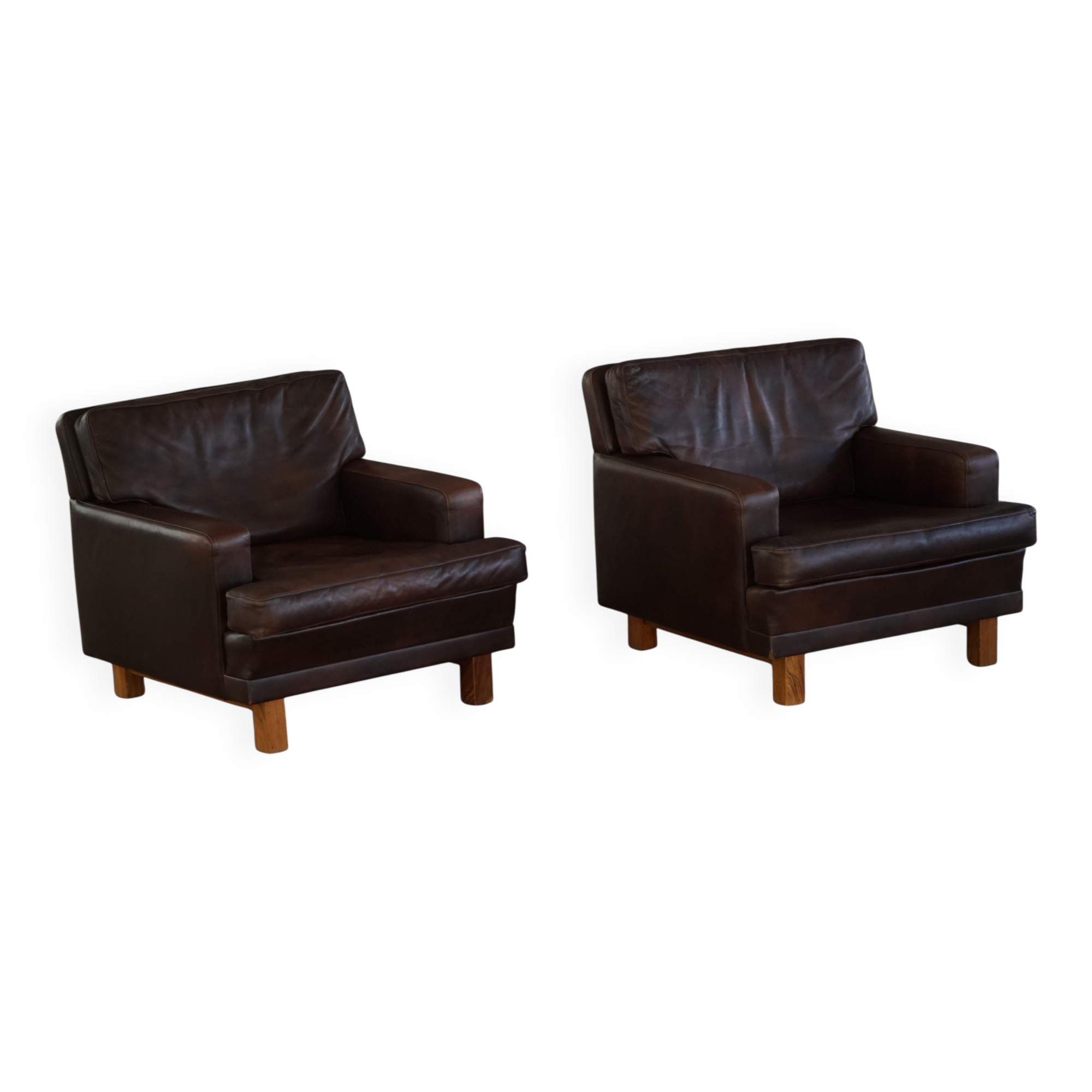 Pair of modern Danish lounge chairs in dark brown leather and rosewood, 1960s.