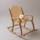 Handcrafted rocking chair in curved wood with a white seat.
