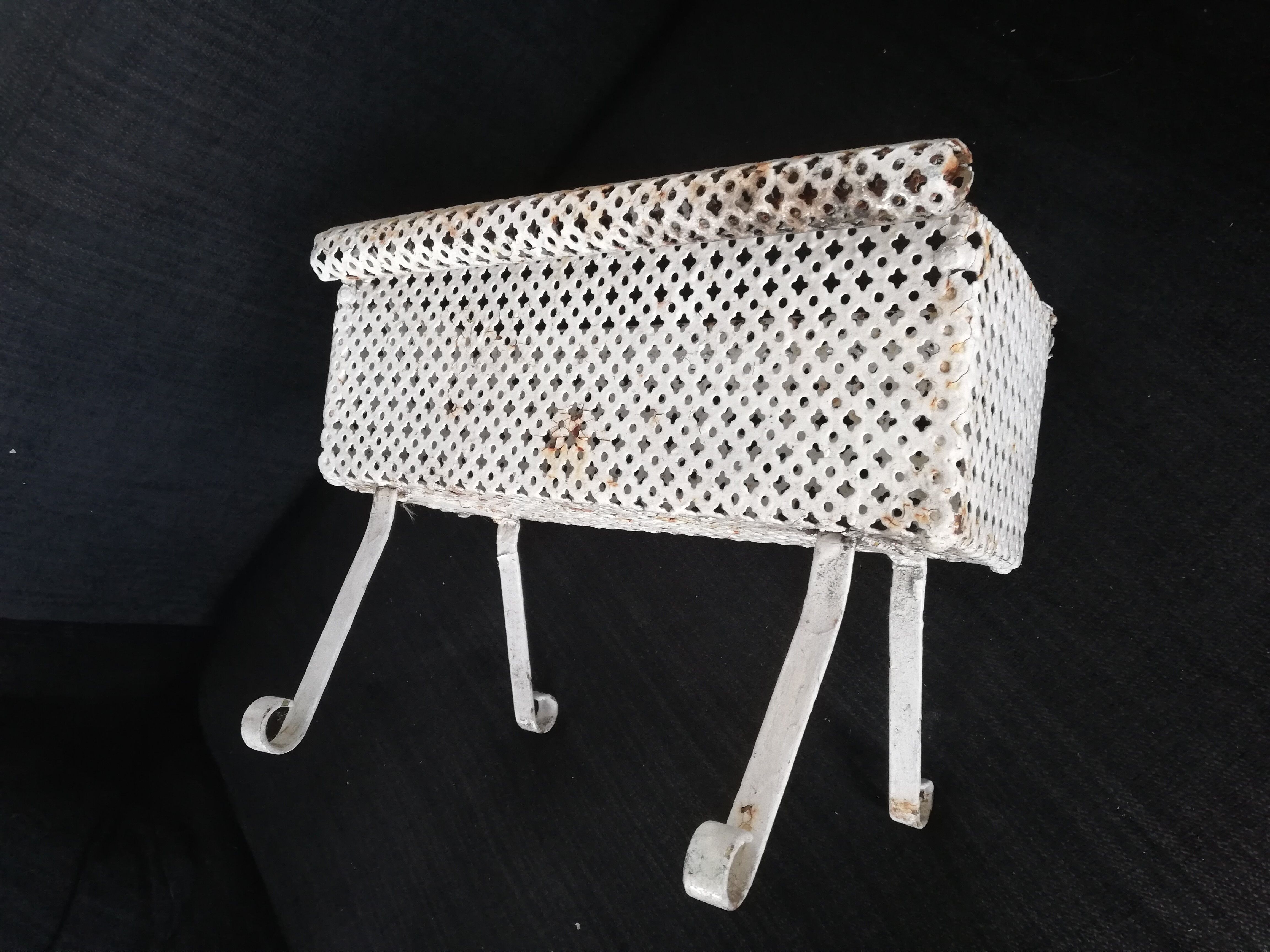 Wrought iron planter hides perforated sheet metal pot